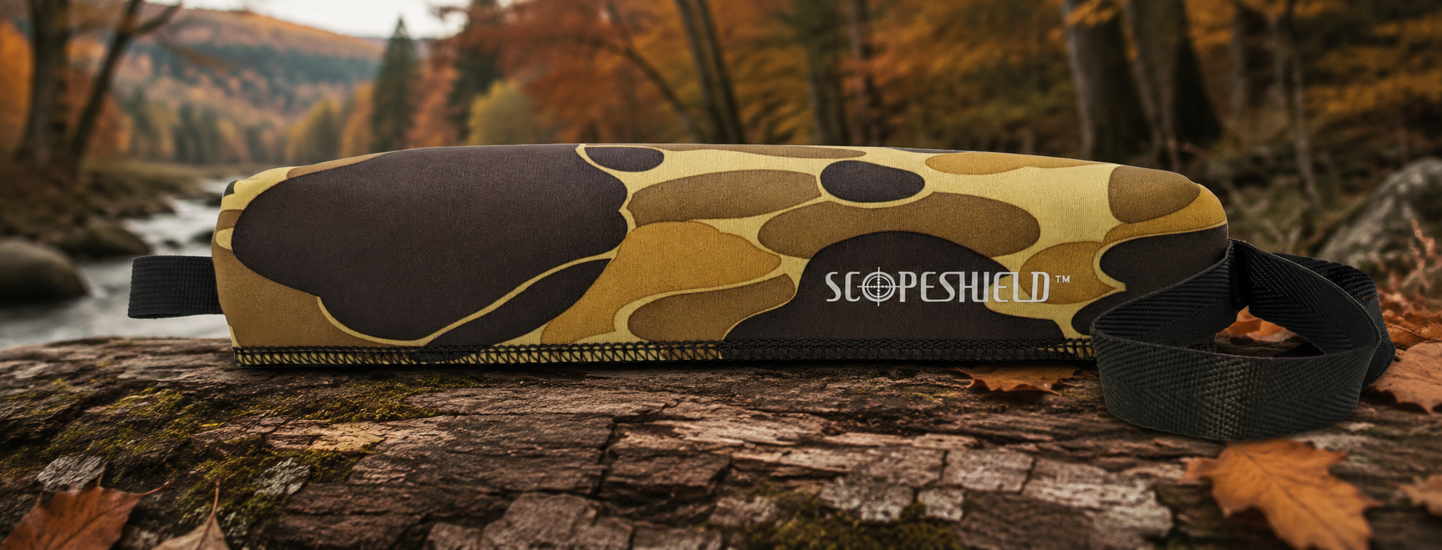 ScopeShield high desert brown camouflage rifle scope cover displayed in an autumn forest setting